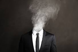 Man in a suit whose head dissolves into smoke